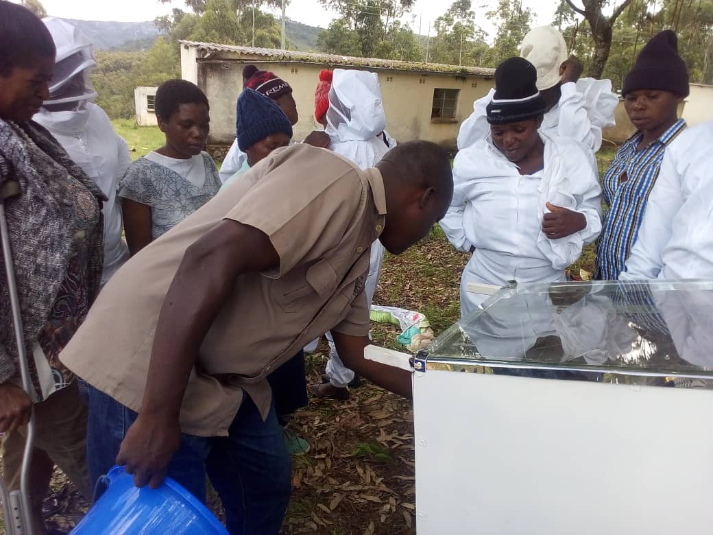 A local agriculture extension officer teaches members of the Odzani Swarm Charm how to separate honey   and wax using a honey separator. As part of the United Methodist Women project, the women manage   beehives and sell the honey and its by-products to provide for their families and local church. Photo   by Kudzai Chingwe, UMNS.
