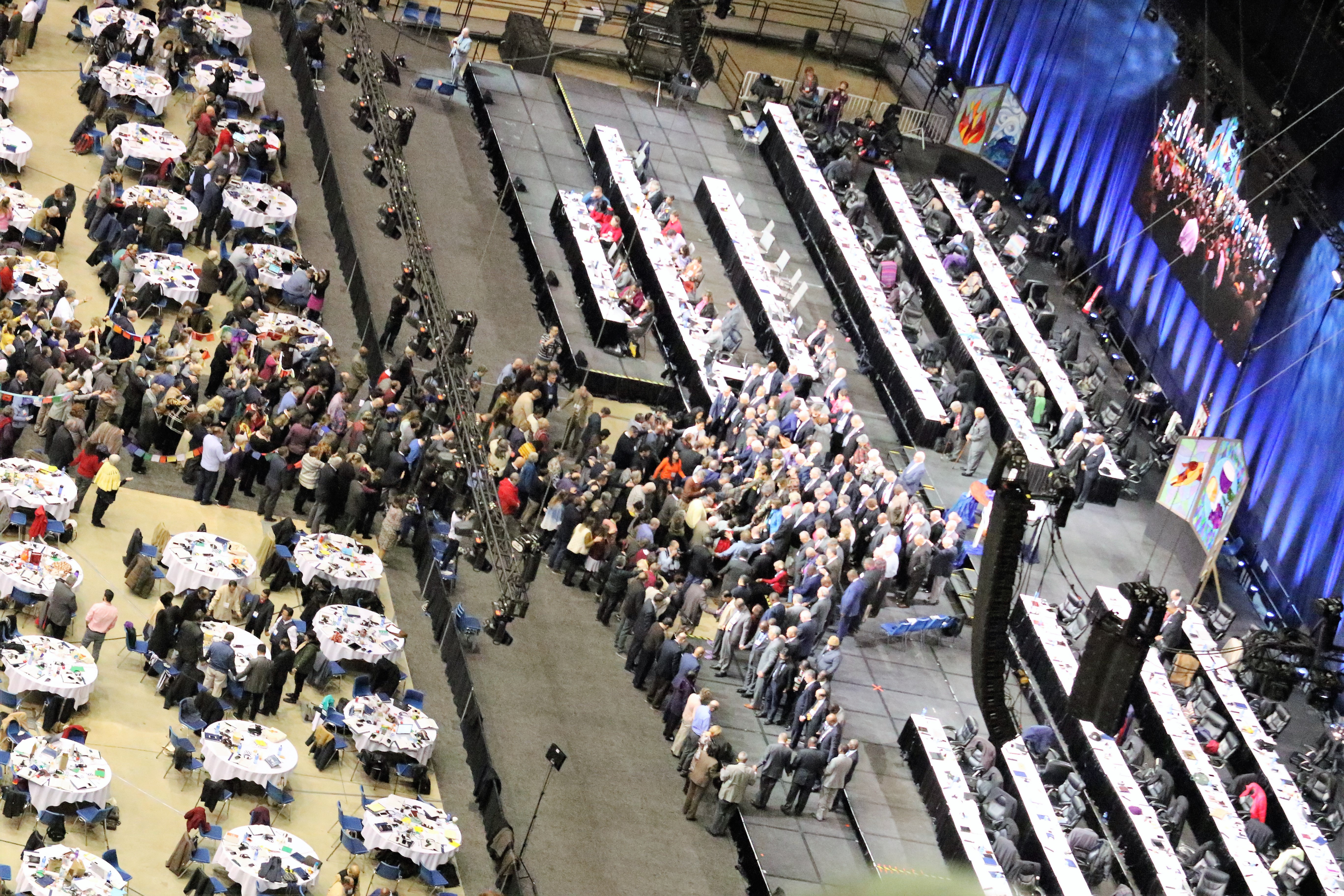 Delegates and bishops join in prayer at the front of the stage before a key vote on church policies about homosexuality during the 2019 United Methodist General Conference in St. Louis. Photo by the Rev. Thomas Kim, UMNS.