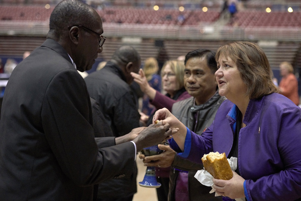 Bishop Karen Oliveto (right) shares bread with a delegate during a February 23, 2019, worship service in the special session of the General Conference of The United Methodist Church. Oliveto leads the Mountain Sky Area of The United Methodist Church.  Photo by Paul Jeffrey, UMNS. Bishop Karen Oliveto (right) shares bread with a delegate during a February 23, 2019, worship service in the special session of the General Conference of The United Methodist Church. Oliveto leads the Mountain Sky Area of The United Methodist Church.  Photo by Paul Jeffrey, UMNS.