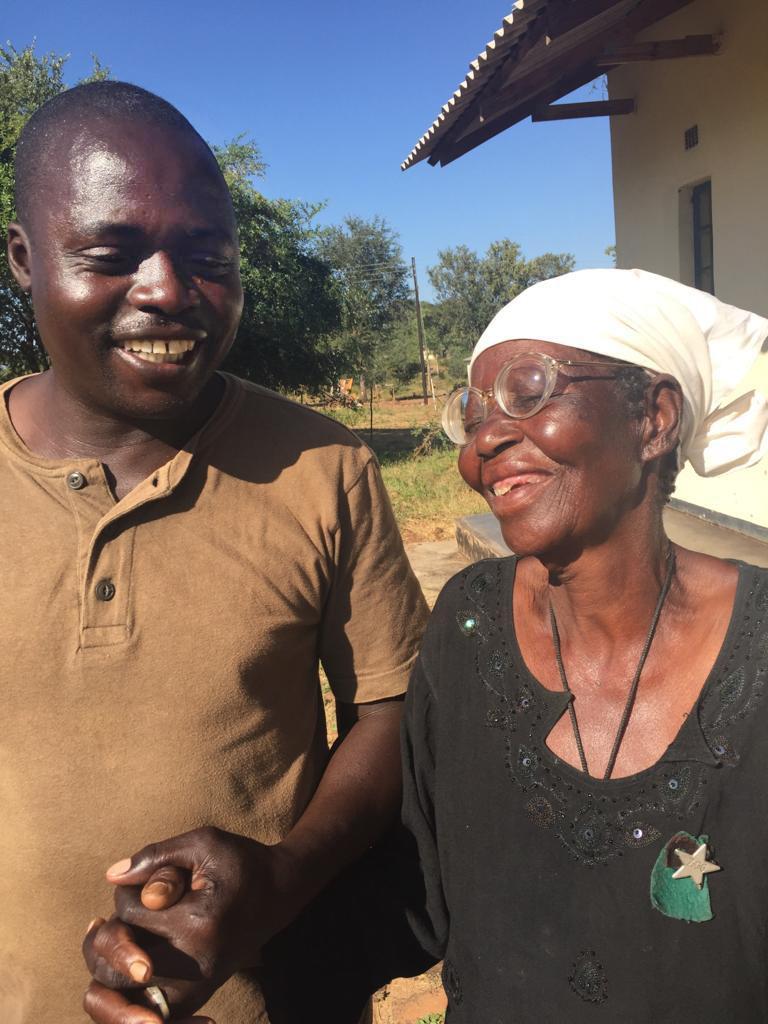 Artwell Chidhakwa, a driver at United Methodist Nyadire Mission Hospital, holds hands with Maduni Jangamu at an eyeglasses clinic in Dindi, Zimbabwe. Photo by Chenayi Kumuterera, UMNS.  Artwell Chidhakwa, a driver at United Methodist Nyadire Mission Hospital, holds hands with Maduni Jangamu at an eyeglasses clinic in Dindi, Zimbabwe. Photo by Chenayi Kumuterera, UMNS.