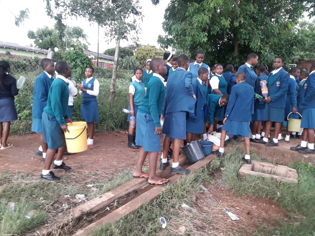 Lydia Chimonyo Girls High School students carry buckets to gather water at a borehole in Chimanimani, Zimbabwe. There is no running water at the school since Cyclone Idai damaged the school’s water plant. Photo by the Rev. Duncan Charwadza.  Lydia Chimonyo Girls High School students carry buckets to gather water at a borehole in Chimanimani, Zimbabwe. There is no running water at the school since Cyclone Idai damaged the school’s water plant. Photo by the Rev. Duncan Charwadza.