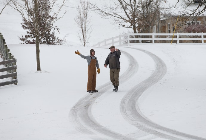 Jim (left), a resident at Jacob's Ladder recovery home, checks in with Mark Utterback, director of farming. Residents help with livestock, bale hay, collect firewood and maintain machinery during their six-month stay. Photo by Mike DuBose, UMNS.