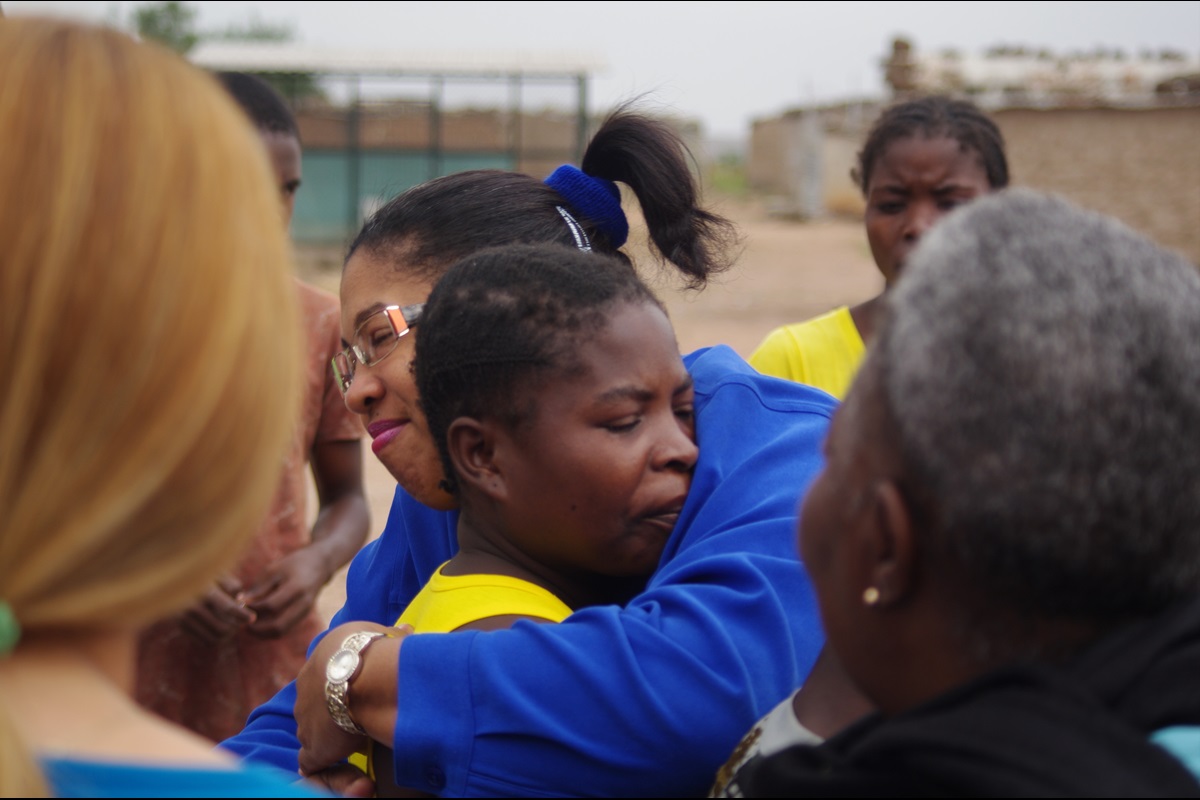 La Rvda. Cleivy Benítez, abraza a una madre que ha perdido su pequeño hijo a causa de una enfermedades tratable. La falta de medicina, educación sanitaria y recursos medicos adecuados cobra muchas muertes infantiles al año en Angola. Foto: Rev. Gustavo Vasquez, Noticias MU.