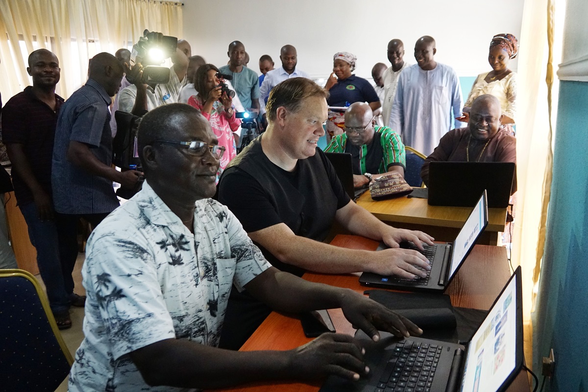 The Rev. John Pena Auta (foreground), provost of Banyan Theological Seminary, works on a computer in the new communications center in Jalingo, Nigeria. Seated next to him is Dan Krause, top staff executive of United Methodist Communications in Nashville, Tenn. In the background are Tafadzwa Mudambanuki (left) from United Methodist Communications and Bishop John Wesley Yohanna of the Nigeria Episcopal Area. Photo by Danny Mai, United Methodist Communications. The Rev. John Pena Auta (foreground), provost of Banyan Theological Seminary, works on a computer in the new communications center in Jalingo, Nigeria. Seated next to him is Dan Krause, top staff executive of United Methodist Communications in Nashville, Tenn. In the background are Tafadzwa Mudambanuki (left) from United Methodist Communications and Bishop John Wesley Yohanna of the Nigeria Episcopal Area. Photo by Danny Mai, United Methodist Communications.