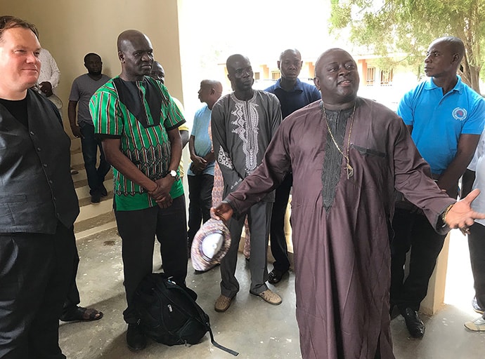 Bishop John Wesley Yohanna, leader of The United Methodist Church in Nigeria, speaks during the dedication of the new communications center in Jalingo on May 30, 2019. Listening at far left is Dan Krause, top staff executive of United Methodist Communications, along with staff member Tafadzwa Mudambanuki, center. Photo by Tim Tanton, UM News.
