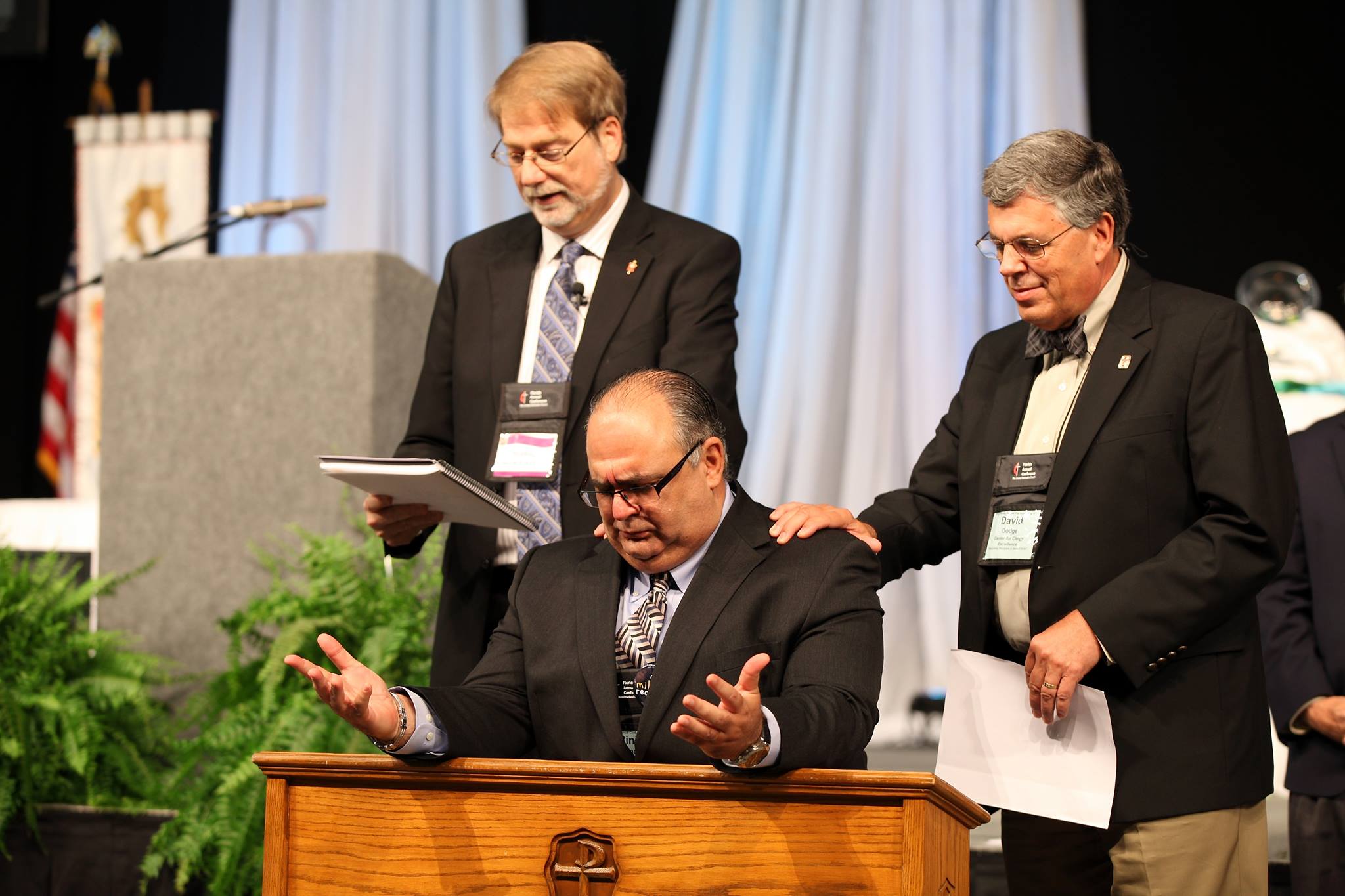 El Rev. Hernández sirvió en la Iglesia Metodista de Cuba  durante 23 años como pastor y superintendente. Es pastor fundador de La Nueva Iglesia, en la ciudad de Miami y se desempeño como Superintendente del Distrito Suroeste de la Conferencia Anual de Florida. En la foto de archivo (2013) el Obispo Kenneth Carter (izquierda) y el Rev. David Dodge (derecha) imponen sus manos sobre Hernández al comisionarle como superintendente. Foto cortesía del Rev. Armando Rodríguez. 