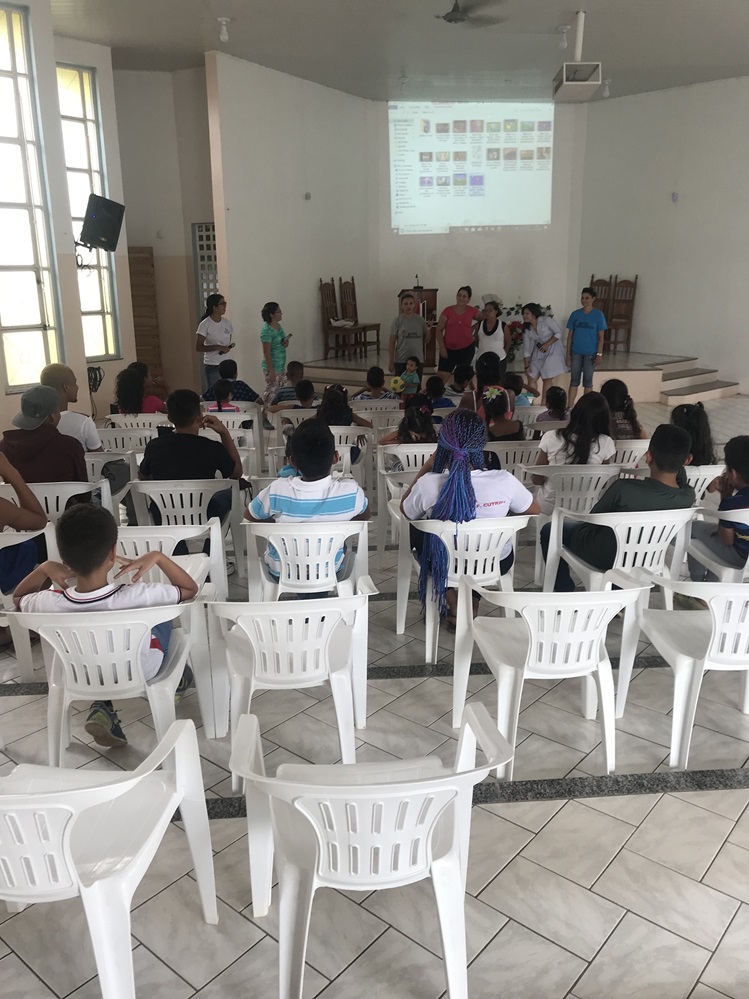 Los niños venezolanos son bienvenidos en la iglesia antes de que se dividan los grupos para las actividades del programa en Boa Vista, a norte de Brasil. Este ministerio es parte del programa “Sombra y Agua Fresca” para recibir a los/as inmigrantes venezolanos/as en territorio brasileño. Foto por Emily Everett, GBGM.