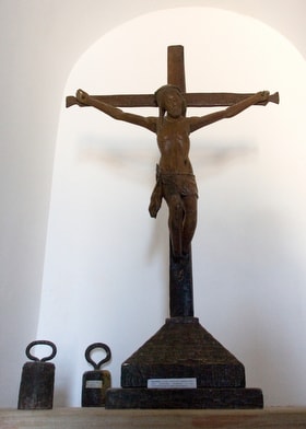 A crucifix and weights that were attached to slaves' chains are on display at the Angola National Slavery Museum, near Luanda in 2006. The exhibit caption on the base of the crucifix reads "Crucifix - religious instrument used by the missionaries, revealing their co-participation in the slave traffic." File photo by Mike DuBose, UM News.