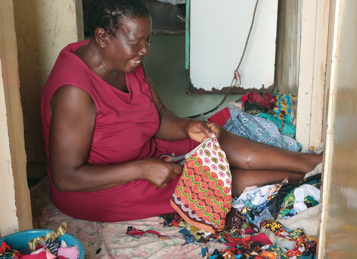 Tapiwa Nyawasha cuts strips from scrap pieces of plastic that she will use to make bed, bath and door mats as a way to increase income and empower widows and single mothers. Tapiwa  is a member of Kuwadzana Extension United Methodist Church in Harare, Zimbabwe. Photo by Chenayi Kumuterera, UM News. Tapiwa Nyawasha cuts strips from scrap pieces of plastic that she will use to make bed, bath and door mats as a way to increase income and empower widows and single mothers. Tapiwa  is a member of Kuwadzana Extension United Methodist Church in Harare, Zimbabwe. Photo by Chenayi Kumuterera, UM News.