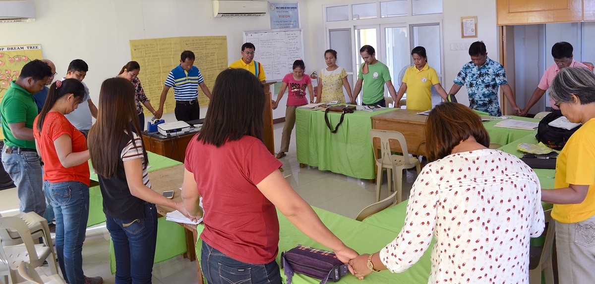 Staff members and management of the Wesley Savings and Multipurpose Cooperative hold hands in prayer during a meeting at their office in San Isidro, Philippines. The cooperative’s purpose is “to alleviate poverty and enhance the dignity and quality of life of people,” said the Rev. Ferdinand J. Valdez, top executive of the cooperative. Photo courtesy of the Rev. Ferdinand J. Valdez. Staff members and management of the Wesley Savings and Multipurpose Cooperative hold hands in prayer during a meeting at their office in San Isidro, Philippines. The cooperative’s purpose is “to alleviate poverty and enhance the dignity and quality of life of people,” said the Rev. Ferdinand J. Valdez, top executive of the cooperative. Photo courtesy of the Rev. Ferdinand J. Valdez.
