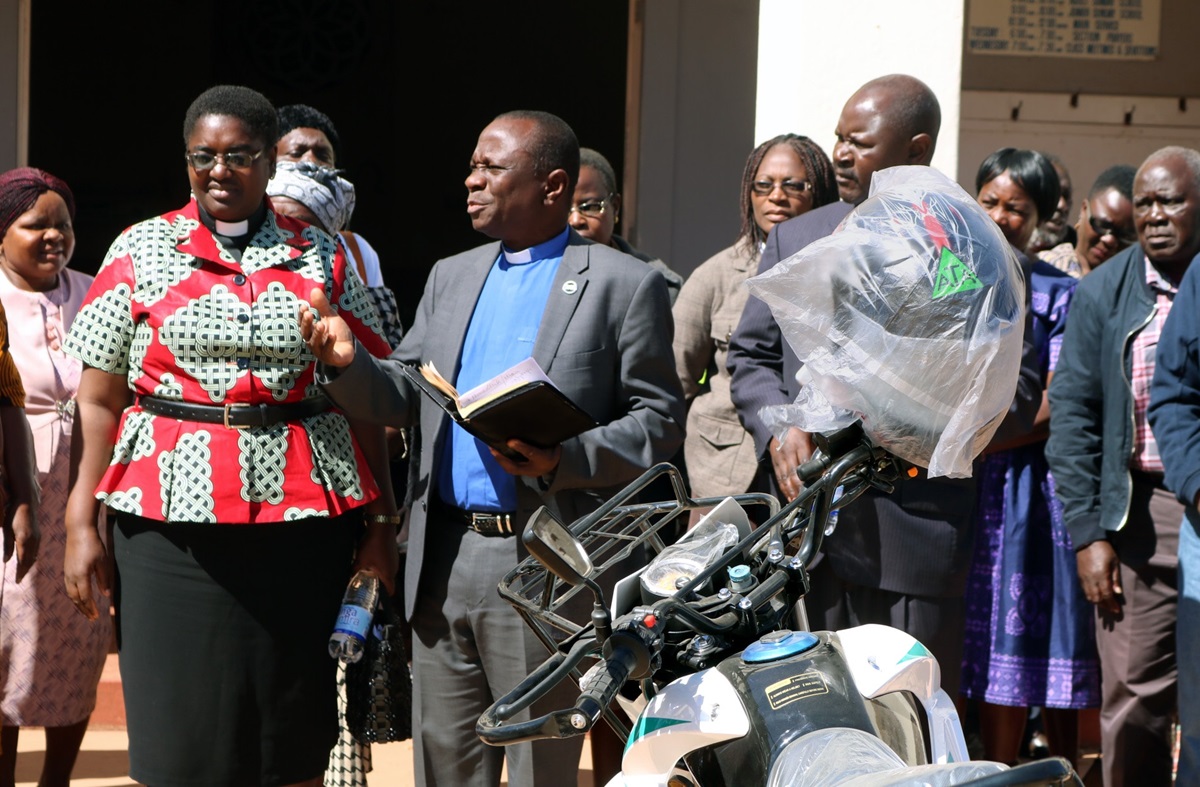 The Rev. Alan Masimba Gurupira (center), officiates a ceremony to present motorbikes to five pastors of the Mutasa Nyanga District of Zimbabwe on July 20. Listening are the Rev. Tafadzwa Musona (left, in red), district superintendent; and the Rev. Duncan Charwadza (right, behind bike), Connectional Ministries director and Deputy Administrative Assistant to the Bishop. The motorbikes were a gift from Mutasa Nyanga Homelink, a group of church members originally from the district, who pool their resources to support the pastors. Photo by  Eveline Chikwanah, UM News. The Rev. Alan Masimba Gurupira (center), officiates a ceremony to present motorbikes to five pastors of the Mutasa Nyanga District of Zimbabwe on July 20. Listening are the Rev. Tafadzwa Musona (left, in red), district superintendent; and the Rev. Duncan Charwadza (right, behind bike), Connectional Ministries director and Deputy Administrative Assistant to the Bishop. The motorbikes were a gift from Mutasa Nyanga Homelink, a group of church members originally from the district, who pool their resources to support the pastors. Photo by  Eveline Chikwanah, UM News.