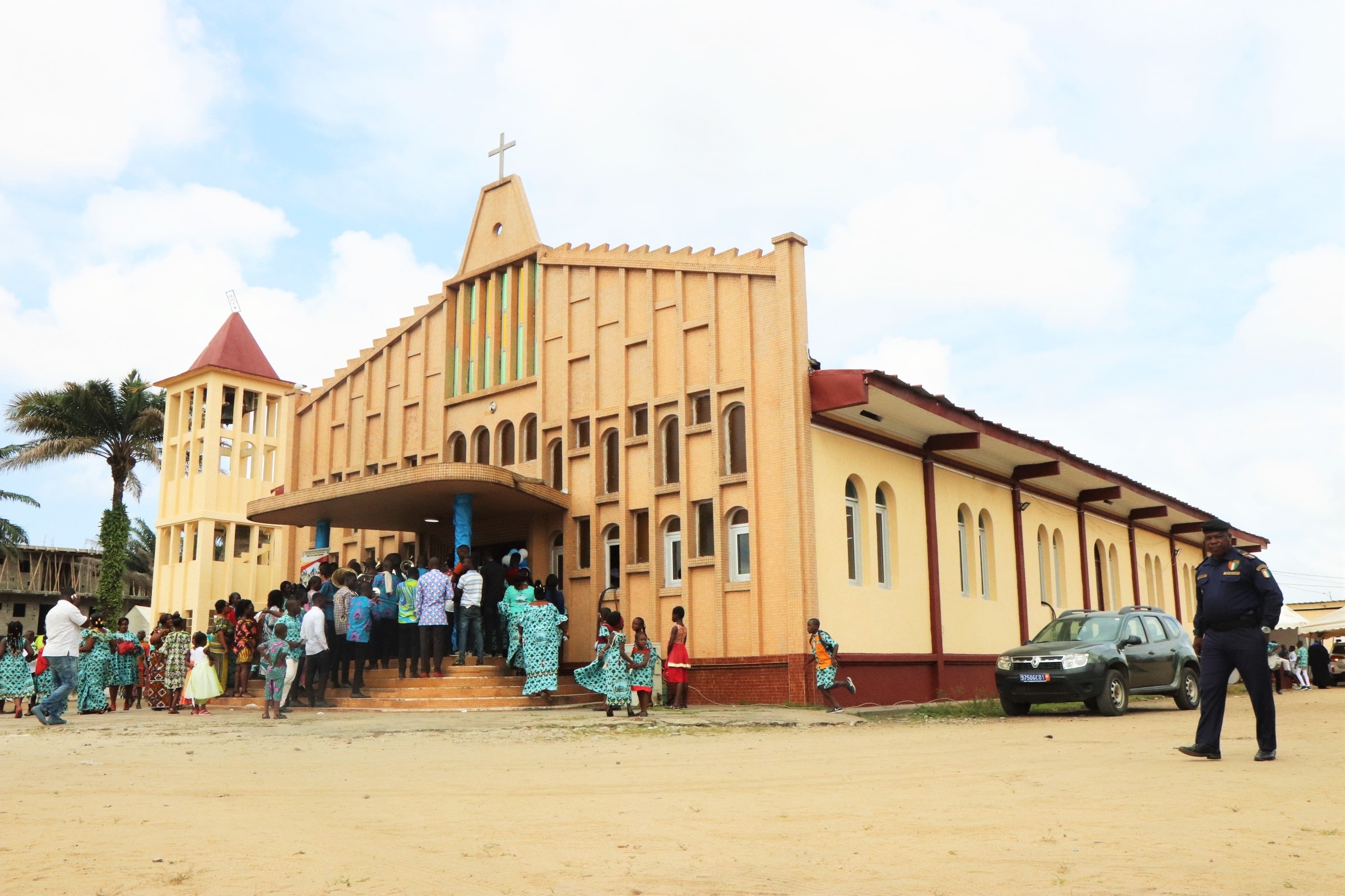 Un policier passe devant le temple de la Cité de grâce d’Anoumabo le jour de la célébration du 25ème anniversaire. Troisième temple construit en matériaux durables depuis l’avènement du Méthodisme dans ce village, il a été dédicacé le 27 février 1994. Photo de Isaac Broune, UM News.