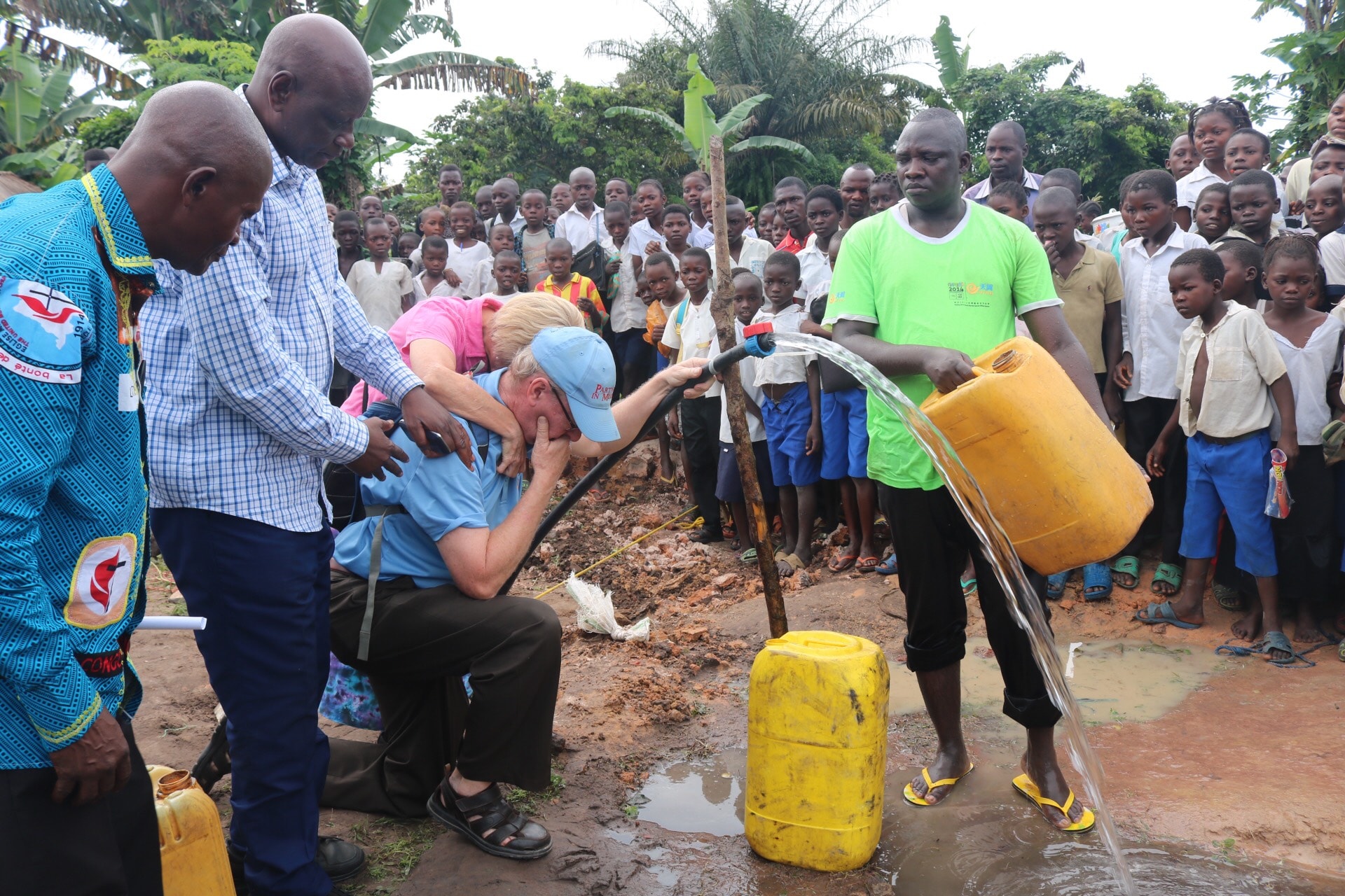 Le couple missionnaire Rev. Jonathan Baker et son épouse Maman Donna sont émus devant les premières sorties d’eau des tuyaux. La population de Wembo-Nyama a longtemps souffert des maladies dues à la mauvaise qualité de l’eau qu’elle consommait. Photo de François Omanyondo, UM News.