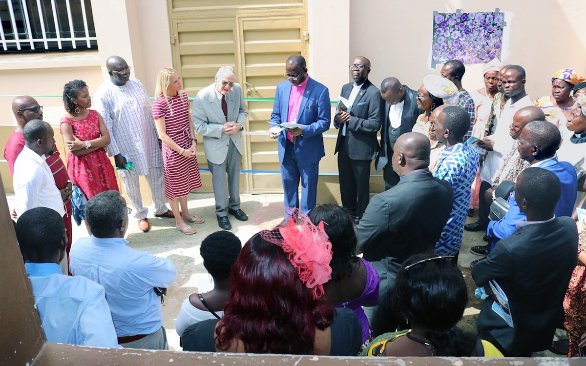 Sierra Leone Area Bishop John Yambasu (center, pink clerical shirt) leads a dedication service in front of the new surgery facility at the Lowell and Ruth Gess United Methodist Eye Hospital in eastern Freetown, Sierra Leone. He is joined by Dr. Lowell Gess (to his right), who started the medical center as Kissy Eye Clinic during his missionary years there. Gess spent 58 of his missionary years in Sierra Leone. Photo by Phileas Jusu, UM News.