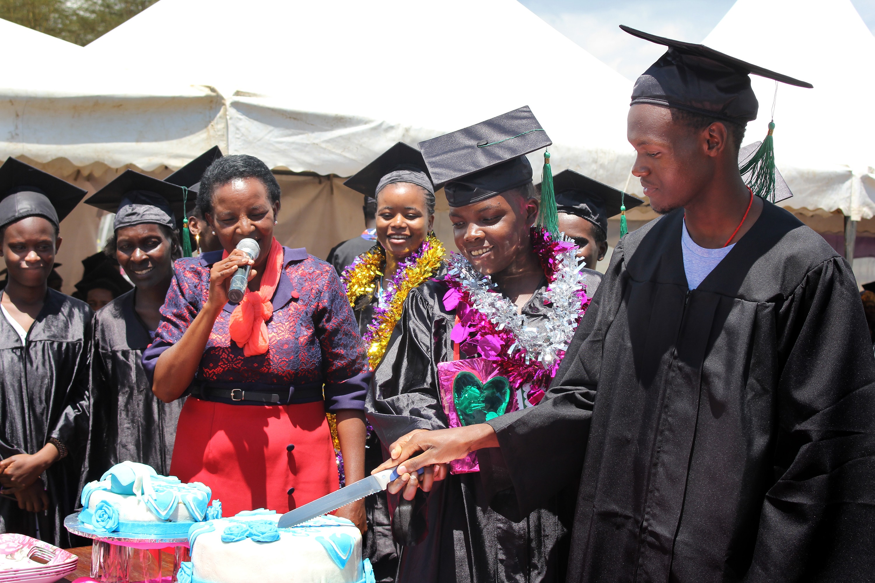 Graduates cut a cake to celebrate their completion of the Inua Partners in Hope vocational training program in Naivasha, Kenya. The program, a partnership between  Trinity United Methodist Church in Naivasha and First United Methodist Church in Winter Park, Fla., teaches vocational and business skills to orphans and vulnerable young people. Photo by Gad Maiga, UM News.