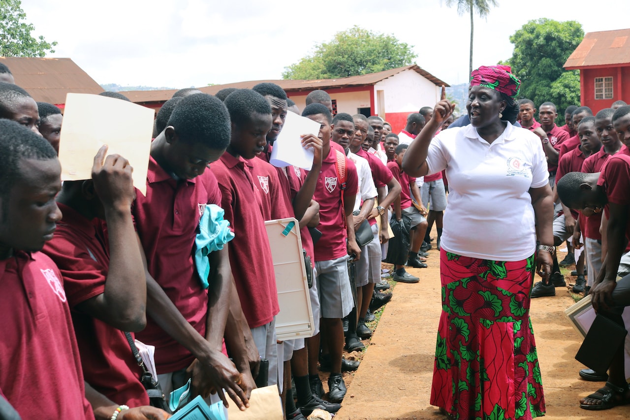 Ethel Sandy, coordenadora das Mulheres Metodistas Unidas (United Methodist Women - UMW), fala com os alunos da Albert Academy - a única escola secundária de meninos Metodistas Unidos em Freetown, Serra Leoa - sobre os perigos de trapacear nos exames. Foto de Phileas Jusu, Notícias MU.