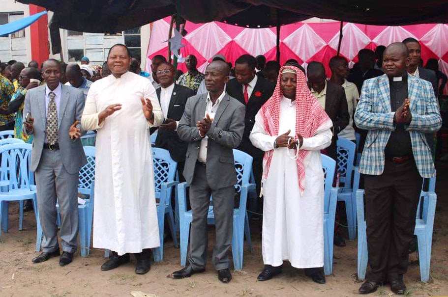 An ecumenical group that includes United Methodists, Roman Catholics, Muslims and other revival churches gather in Lodja, Congo, for a prayer gathering for a peaceful election process in the Sankuru Province. In the black pastoral dress is the Rev. Robert Shuyaka, a United Methodist pastor. Photo by Francois Omanyondo, UM News. 