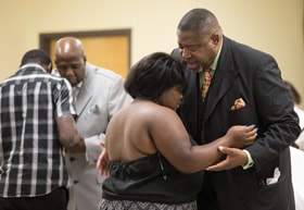 The Rev. Mark Windley (right) prays with parishioner Jada Roarx at Amazing Grace Community of Faith in Louisville, Ky. Photo by Mike DuBose, UMNS.