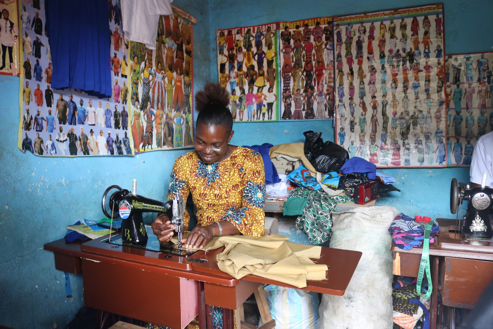 Marian Sao Ensah, a new graduate of the Bo Women’s Training Center, works with a team of tailors at Old Railway Line in Bo, Sierra Leone. Ensah, a single mother of four, said the skills training she received has made it easier for her to provide for her children. Photo by Phileas Jusu, UM News.