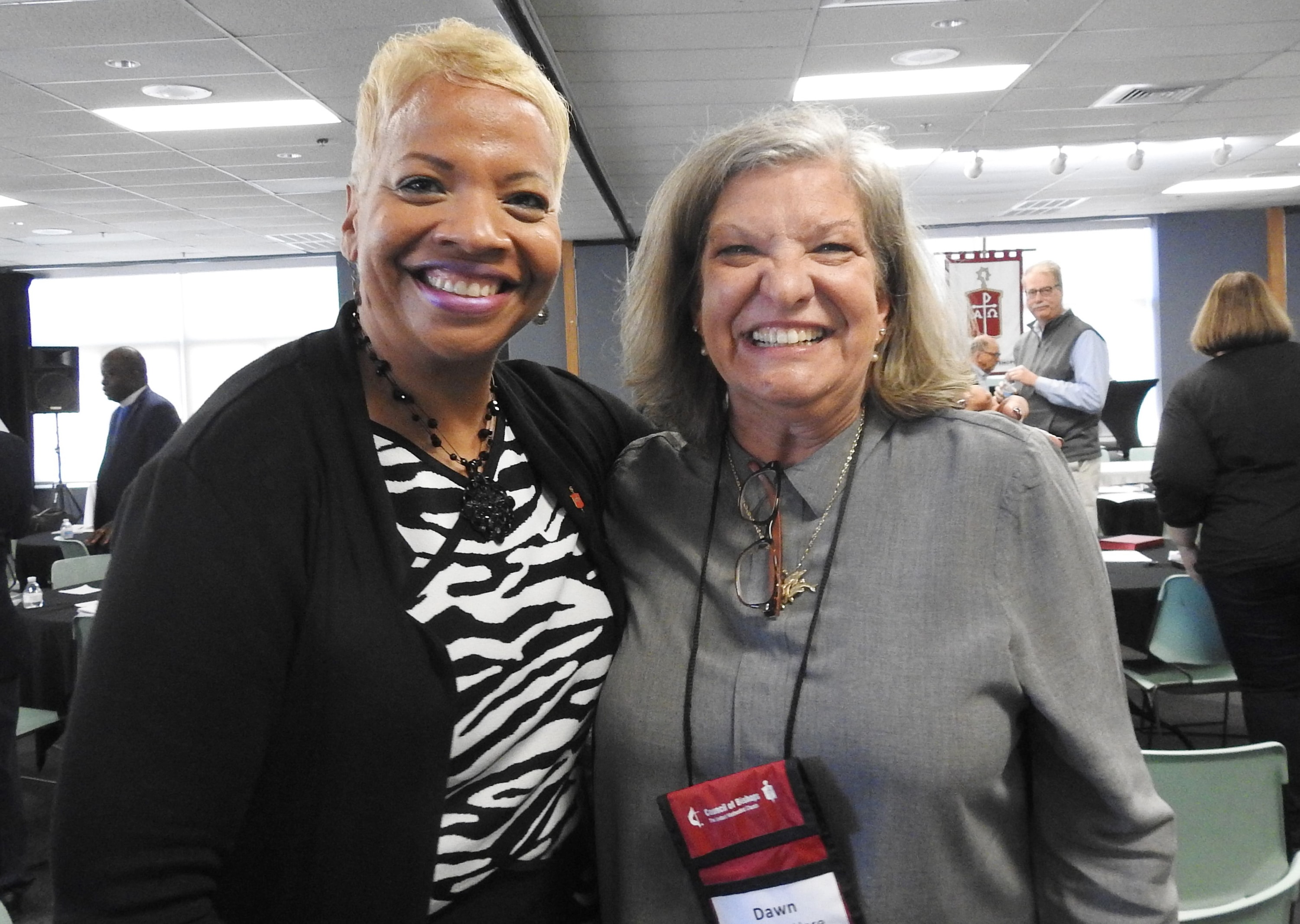 United Methodist Bishop Tracy Smith Malone (left) and Dawn Wiggins Hare celebrate an amendment to the denomination’s constitution that proclaims “men and women are of equal value in the eyes of God.” Ratification of the amendment was announced during the United Methodist Council of Bishops meeting in Lake Junaluska, N.C. Photo by Sam Hodges, UM News.