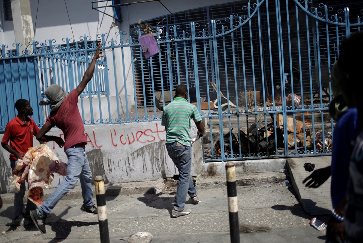 Protesters throw garbage at the entrance of the Immigration and Emigration Direction nel Moise, in the streets of Port-au-Prince, Haiti, October 28, 2019. REUTERS/Andres Martinez Casares. Protesters throw garbage at the entrance of the Immigration and Emigration Direction nel Moise, in the streets of Port-au-Prince, Haiti, October 28, 2019. REUTERS/Andres Martinez Casares.