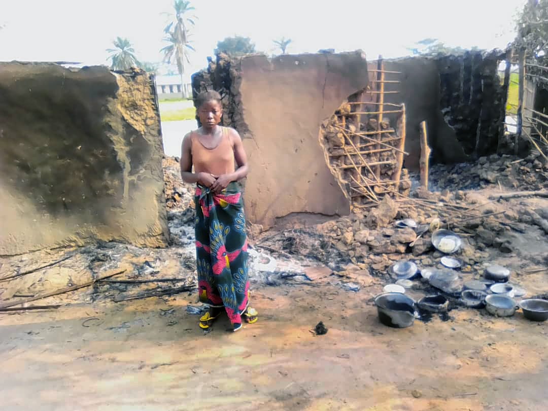 Thérèse Otshumba Shaku, épouse du révérend Maurice Sona Shaku, pasteur méthodiste uni, se tient devant ce qui reste de la maison familiale après un incendie. Les Shakus sont en train de se reconstruire avec le soutien d'autres méthodistes unis. Photo de François Omanyondo Djonga, Nouvelles UM.