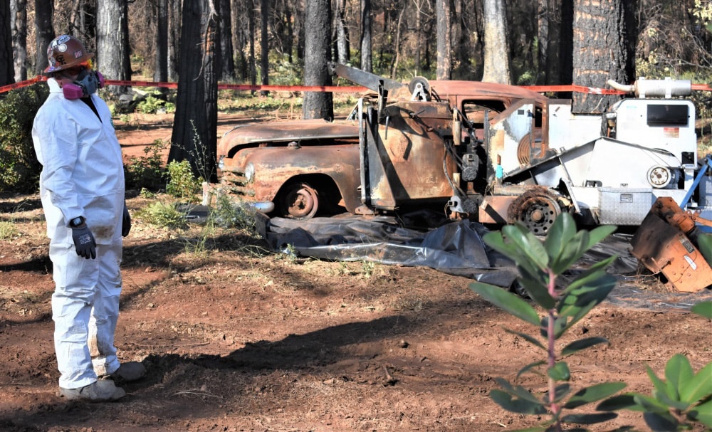 A contractor in protective gear studies one of the last remaining lots being cleared of hazardous soil in Paradise, Calif., on Nov. 4, 2019. Wildfires have damaged or destroyed at least 198,392 acres in the state. Photo by Staff Sgt. Amanda Johnson of the California National Guard. Courtesy Defense Visual Information Distribution Network.
