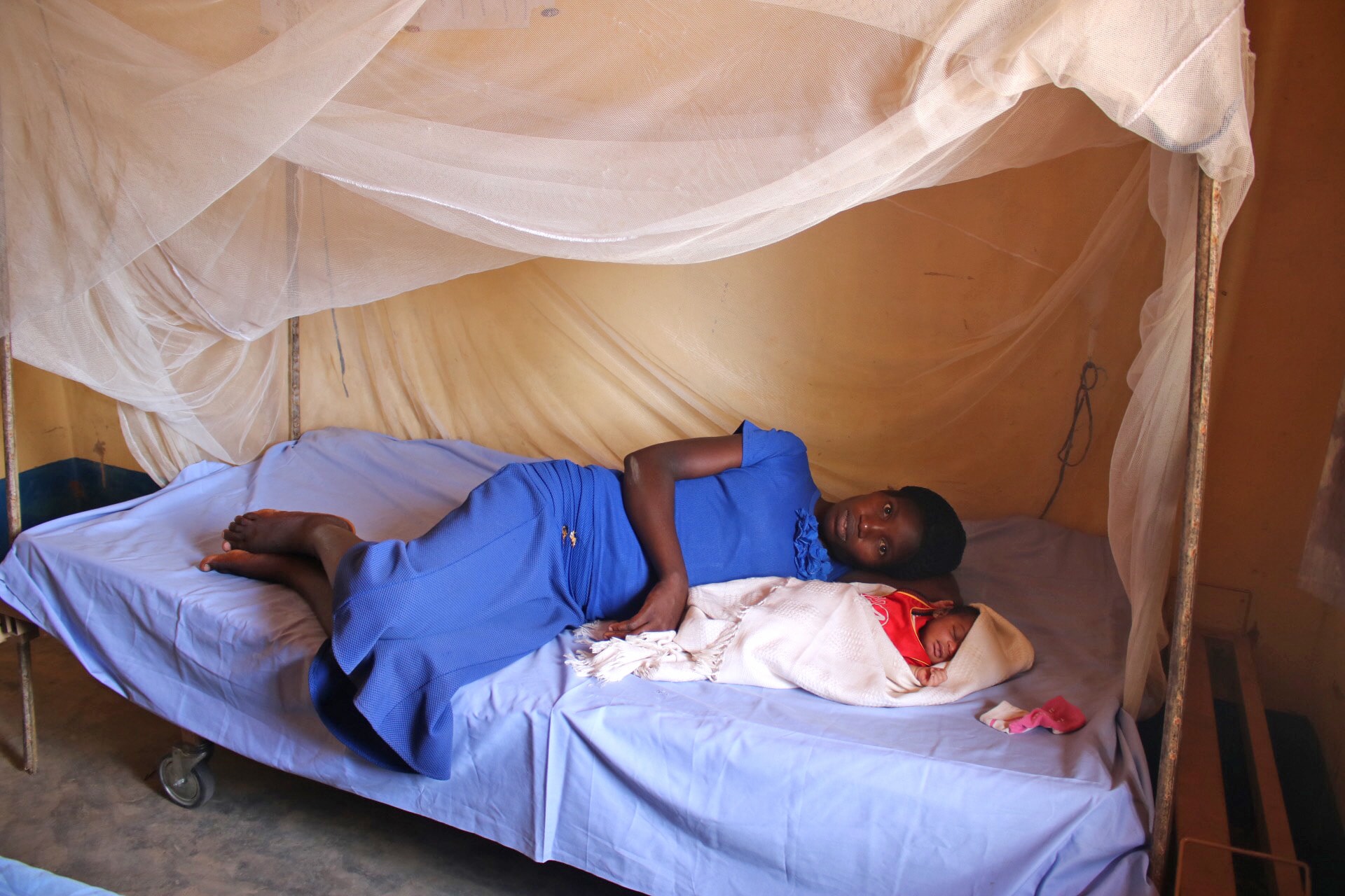 Madame Marie Kombe qui vient d'accoucher d'un petit garçon à la maternité Dingele se repose sur le lit avec son bébé. L'Eglise Méthodiste Unie a construit et équipé la maternité de Dingele dans le cadre du programme de santé globale dans la Conférence Annuelle du Congo Central. Photo de François Omanyondo Djonga, UMNS.