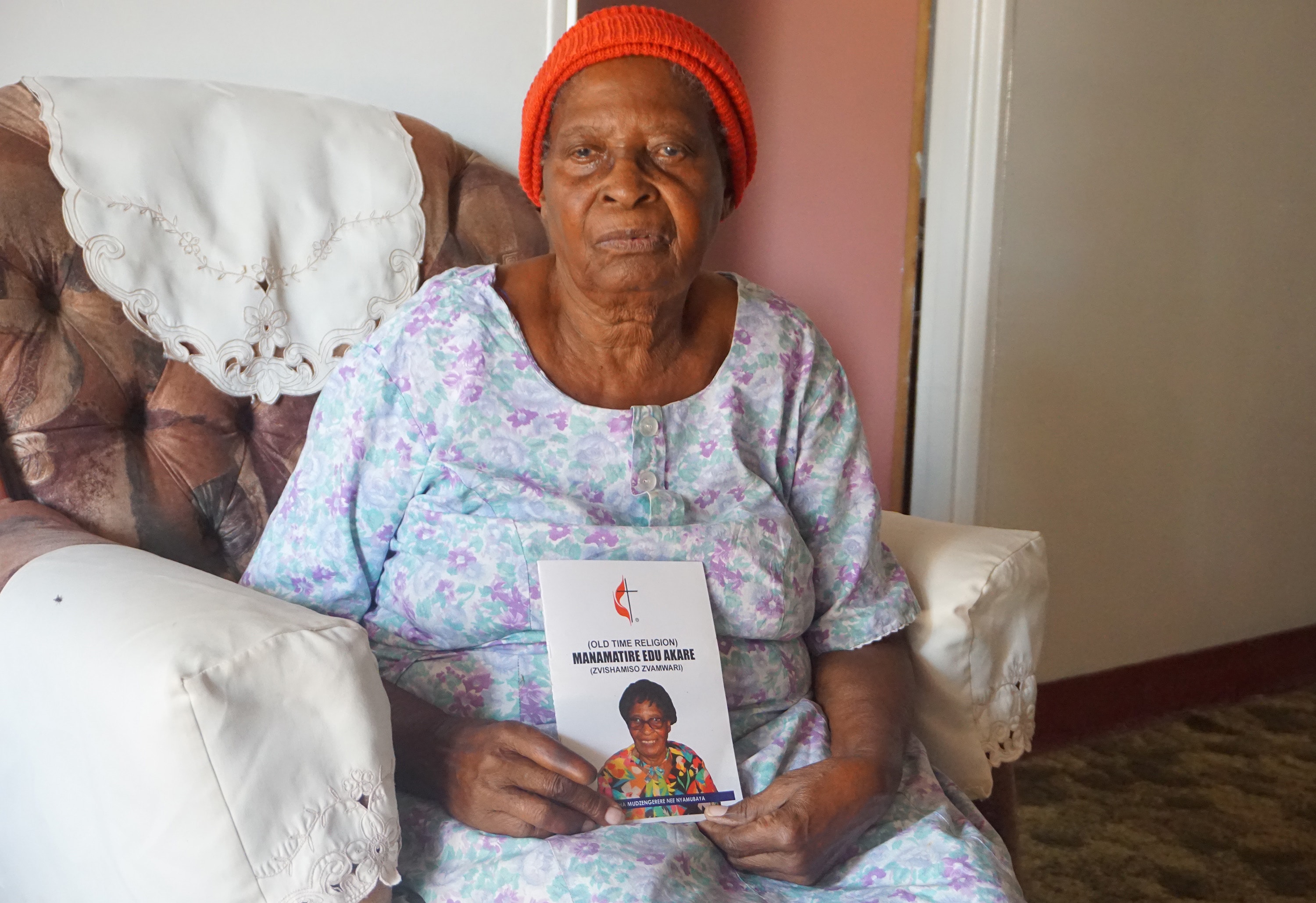 Martha “Granny” Mudzengerere shows off her new book, “Old Time Religion,” which includes spiritual guidance and history about The United Methodist Church in Zimbabwe. It is the 104-year-old’s first book. Photo by Kudzai Chingwe, UM News.