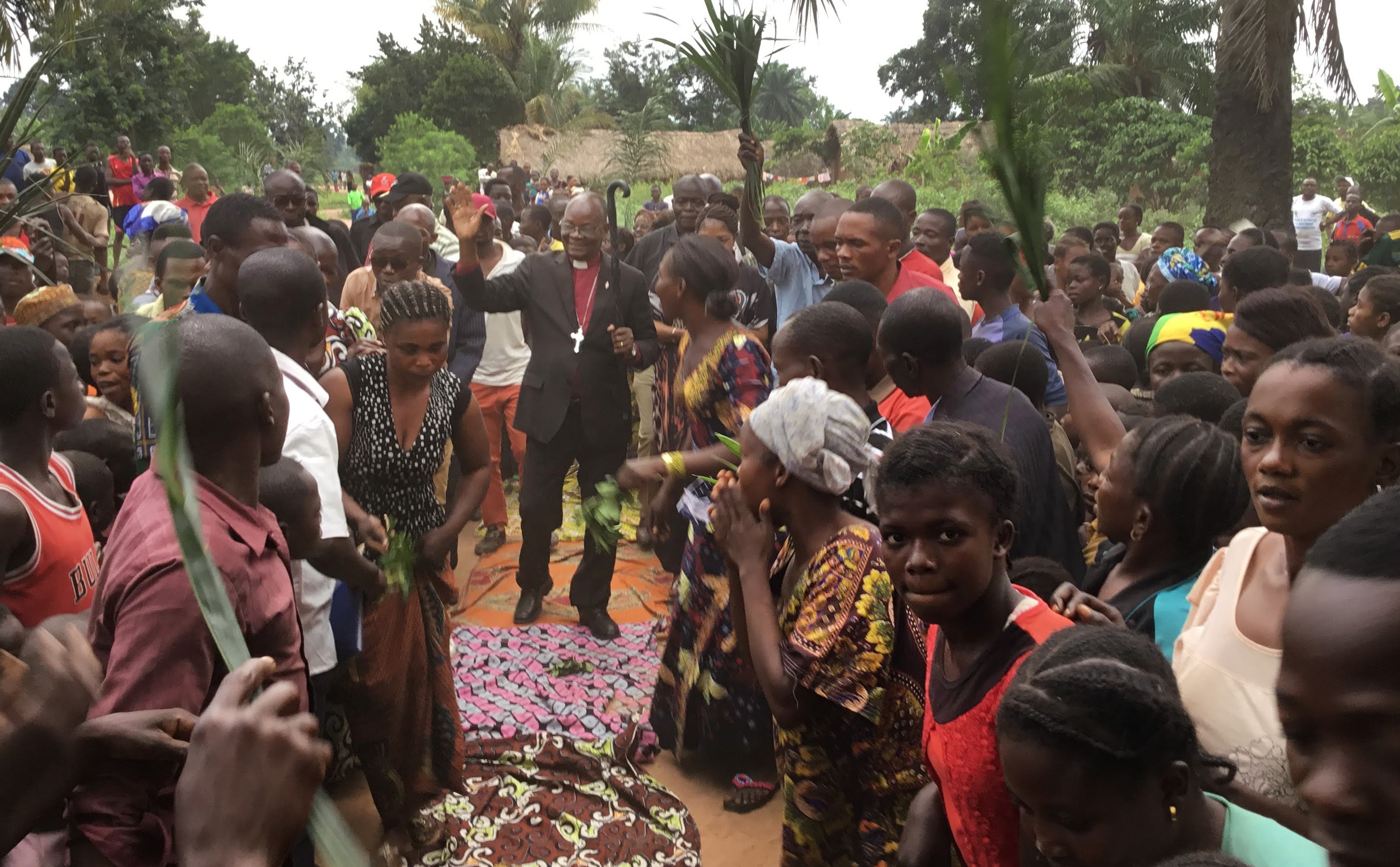 People in the village of Samba, Congo, line the streets to welcome East Congo Bishop Gabriel Yemba Unda, who spent 10 days in late September and early October visiting all seven districts in the remote East Congo Conference. It was the first time many United Methodists in the area had ever seen a bishop. Photo by Judith Osongo Yanga, UM News.