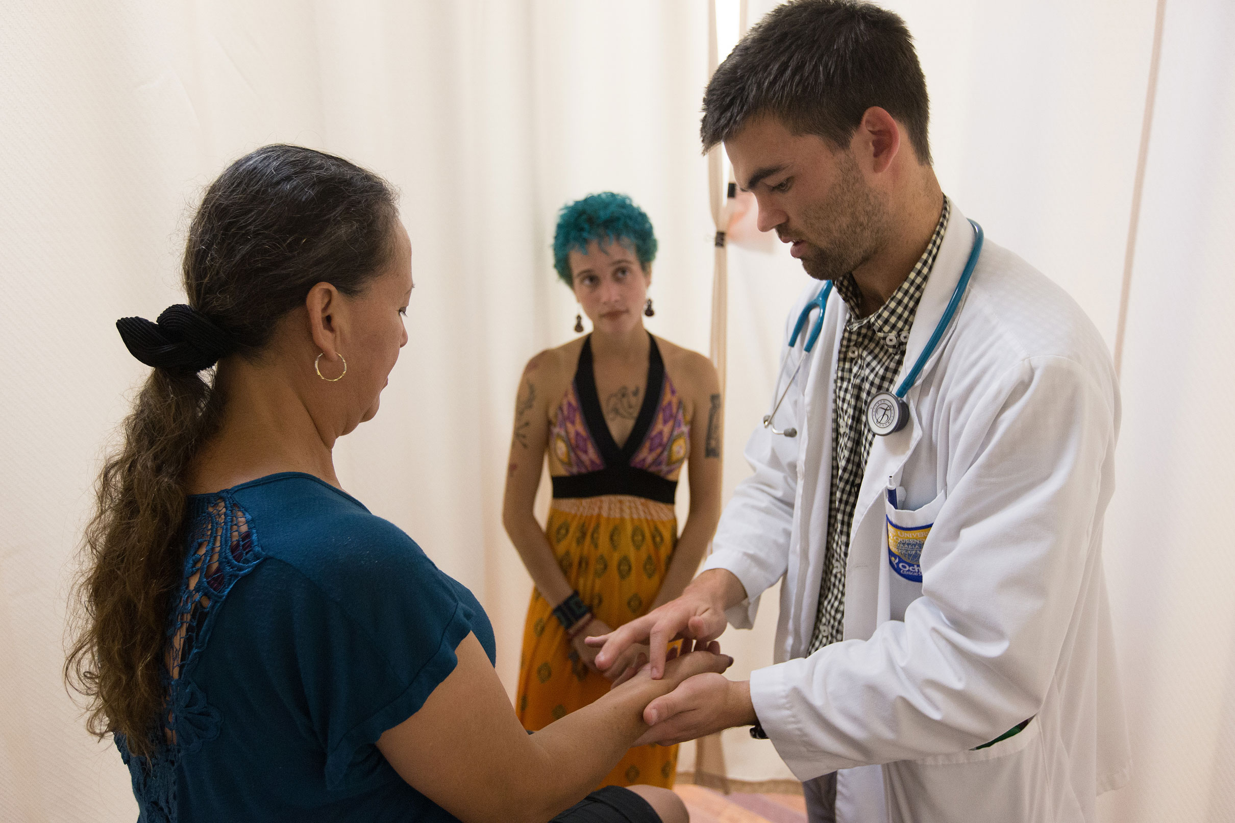 Medical student Joseph Pummer examines a patient during a free medical clinic at Luke's House in New Orleans. At center, helping with Spanish translation, is Paloma Ellis, a public health practicum student from Tulane University. Luke's House is a partnership between Rayne United Methodist Church, Mount Zion United Methodist Church and the LSU Department of Medicine/ Pediatrics Residency Program. Photo by Mike DuBose, UMNS.
