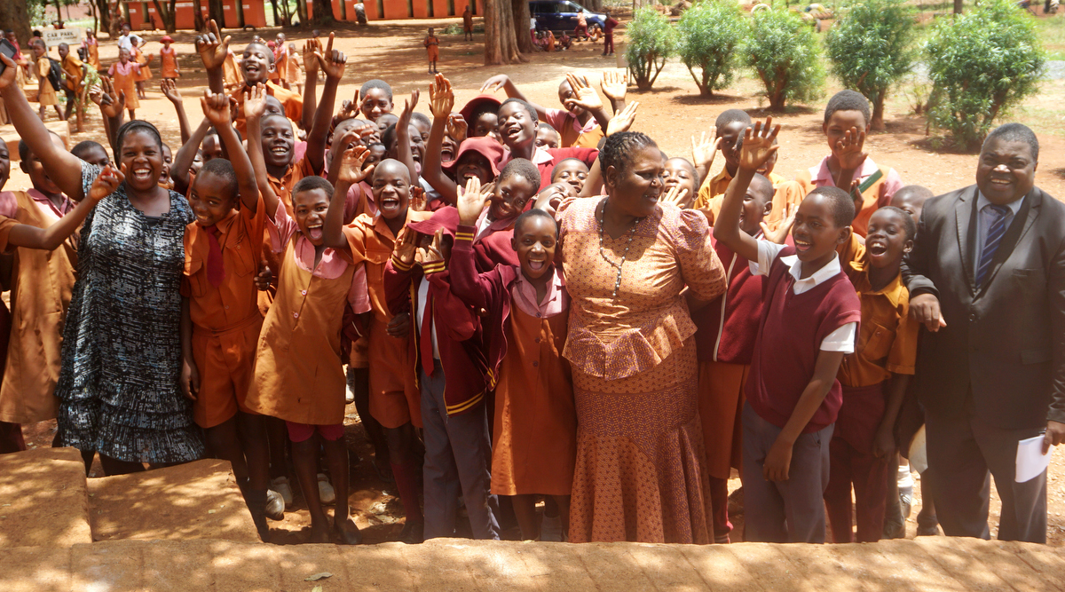 Elasto Musakanda (à droite), directeur de l'école primaire de Pagejo Rarubi, rit avec les élèves et le personnel de la ferme de Pagejo Rarubi dans la campagne zimbabwéenne. L'Eglise Méthodiste Unie établie sur la propriété paie les frais de scolarité de 20 élèves par an et fournit des fournitures et d'autres formes de soutien, a-t-il dit. Photo de Kudzai Chingwe, UM News. Elasto Musakanda (à droite), directeur de l'école primaire de Pagejo Rarubi, rit avec les élèves et le personnel de la ferme de Pagejo Rarubi dans la campagne zimbabwéenne. L'Eglise Méthodiste Unie établie sur la propriété paie les frais de scolarité de 20 élèves par an et fournit des fournitures et d'autres formes de soutien, a-t-il dit. Photo de Kudzai Chingwe, UM News.