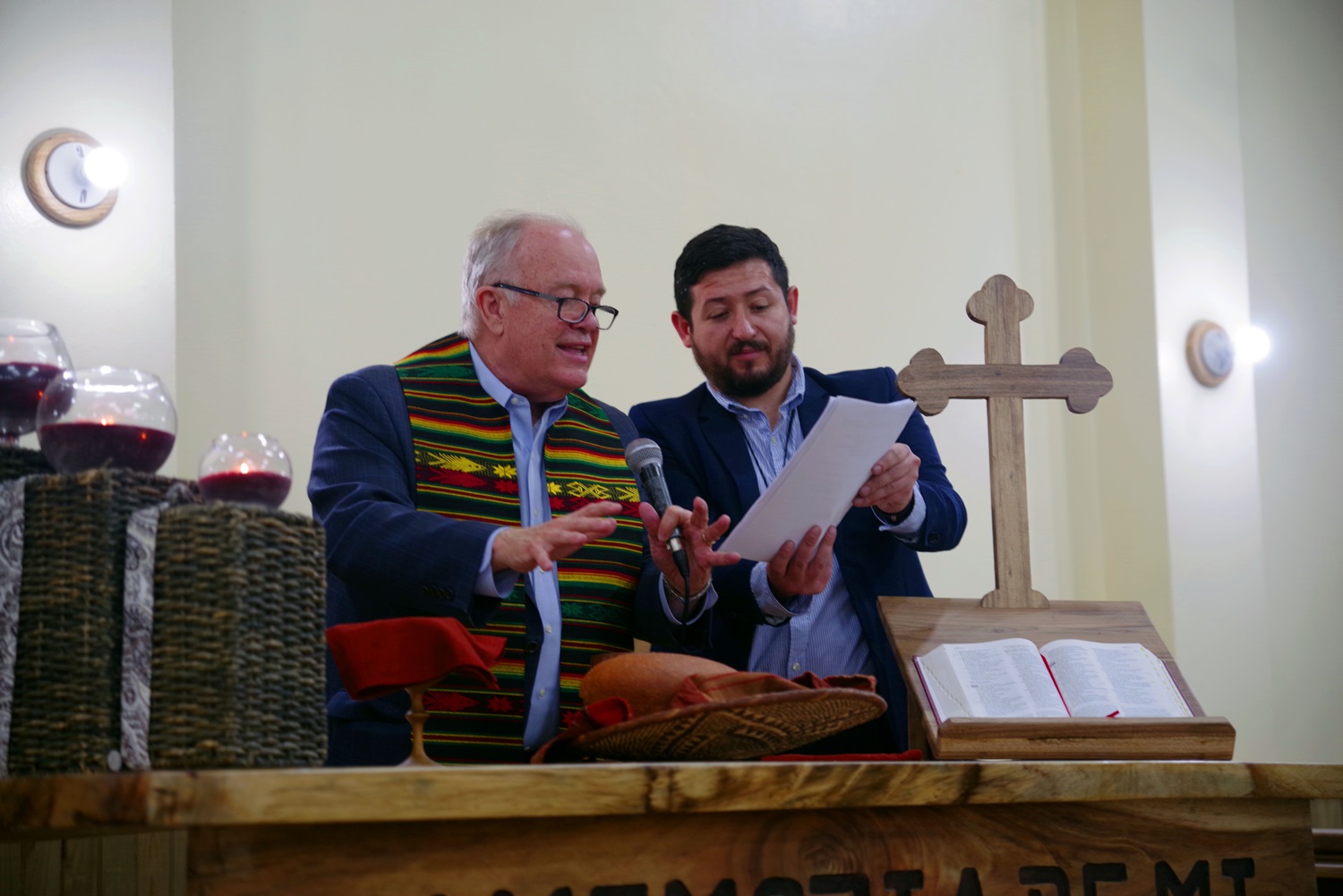 El Obispo Mikel McKee, consagra los elementos de la comunión asistido por el misionero Cristian Schlick. Foto Rev. Gustavo Vasquez, Noticias MU.