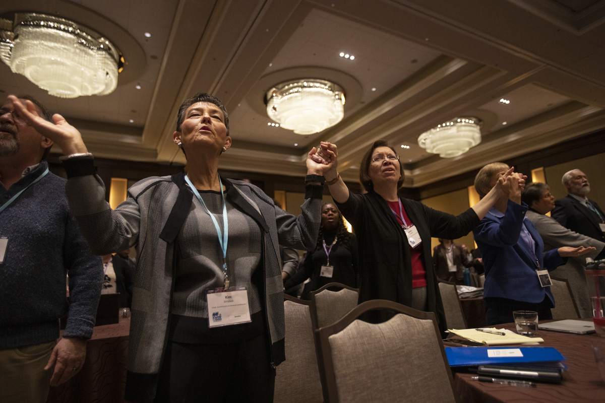 Kim Simpson, chair, Commission on General Conference, and Janice Griffith, Illinois Great Rivers, join hands in prayer during opening worship at the 2020 United Methodist Pre-General Conference held in Nashville, Tenn. Photo by Kathleen Barry, UM News. Kim Simpson, chair, Commission on General Conference, and Janice Griffith, Illinois Great Rivers, join hands in prayer during opening worship at the 2020 United Methodist Pre-General Conference held in Nashville, Tenn. Photo by Kathleen Barry, UM News.