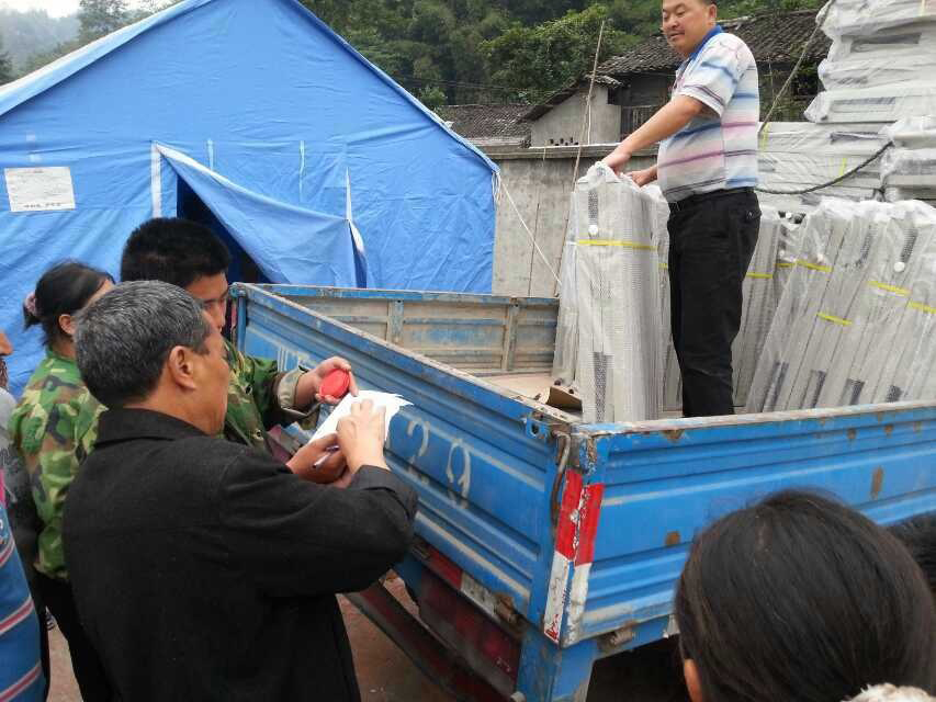 Amity Foundation staff members distribute folding beds to survivors following an April 20 earthquake in western China. Photo courtesy of the Amity Foundation.