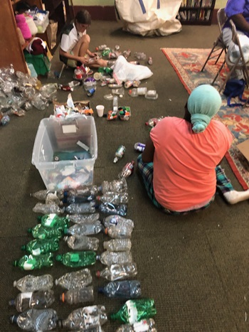 De izquierda a derecha están Amber Harrison y Celeste Vanhoose, quienes quitan las etiquetas y comprimen botellas de plástico para triturarlas. Foto de Mollie Erickson