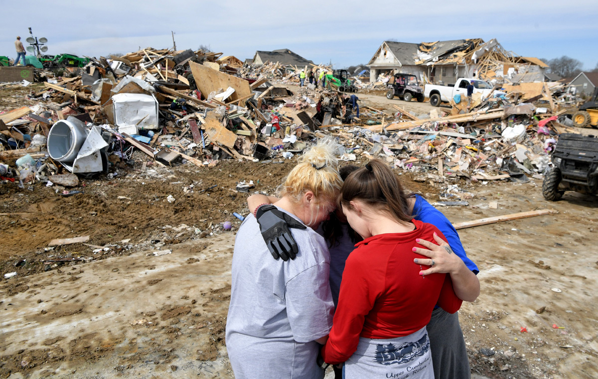 Lindsey Holloway y Melody Montgomery abrazan y oran por Donna Barnett y su hija Jessica Garrett el miércoles 4 de marzo de 2020 en Cookeville, Tennessee, luego de que un tornado impactara su comunidad la madrugada del 3 de marzo. Foto cortesía de © Shelley Mays / The Tennessean - USA TODAY Network a través de Imagine Content Services, LLC.