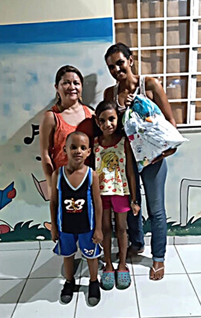 Familia de Charlys Morffi, reasentada en Betim, estado de Minas Gerais. Marjorys Venezuela León Escobar, a la derecha, es la esposa de Morffi. Zarick Cristina Morffi (8), es su hija y Jeremias Daniel Morffi (6), su hijo. La directora del programa Boa Vista, Marcia Cardias (esquina izquierda). Esta familia se vio afectada y su vida se transformó con la entrega del kit de emergencia. Foto cortesía de Iglesia Metodista en Brasil