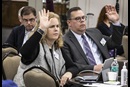 Christine Dodson and the Rev. David Bell, General Council of Finance and Administration board members, raise their hands during a meeting at Scarritt Bennett Center in Nashville, Tenn. The board voted to send the smallest budget the General Conference in more than 30 years. Photo by Kathleen Barry, UM News.