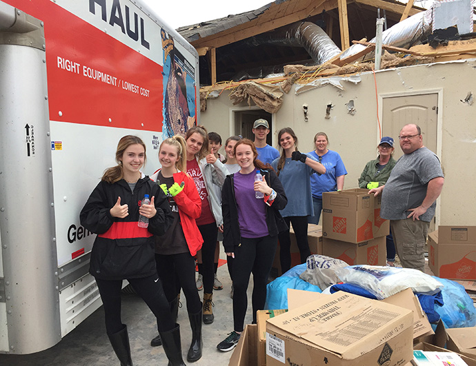 Youth members of First United Methodist Church Jonesboro (Ark.) and their parents work together to help move items out of a home damaged by the tornado in Jonesboro, Ark., in first days after storm. Volunteers are asked to wait until the COVID-19 threat is over. Photo courtesy of First United Methodist Church Jonesboro.