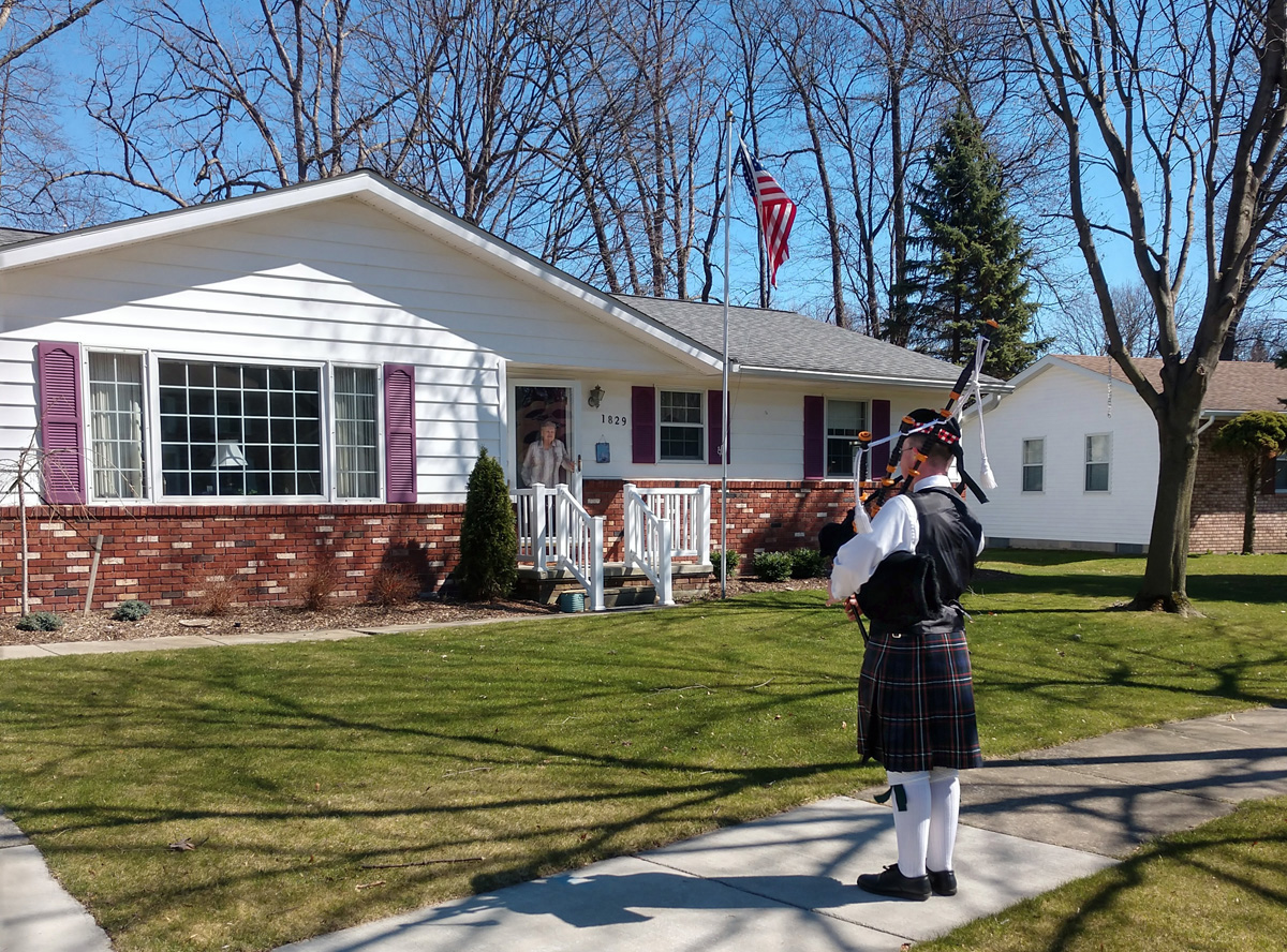 Wyatt Clarke, 15, plays bagpipes outside the house of a neighbor in Marysville, Michigan. The teen has been playing bagpipes to provide entertainment and solace to residents self-isolating during the coronavirus pandemic. Photo courtesy of Marysville United Methodist Church.