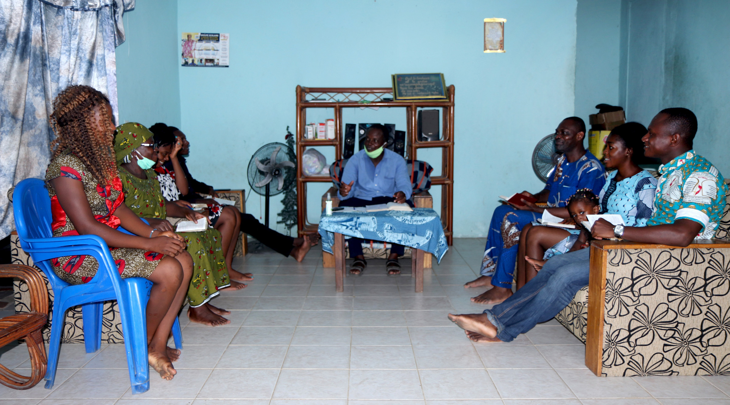 Jacob N'Guessan (chemise bleue), conducteur de Classe Méthodiste Unie de l'église Méthodiste Unie Bethel Quartier-Eléphant, dirige un culte à domicile avec sa famille. Bien que les églises soient fermées à cause de la pandémie du COVID-19, les membres organisent des cultes à domicile avec les ressources fournies par leurs pasteurs. Photo de John Mel, UM News.
