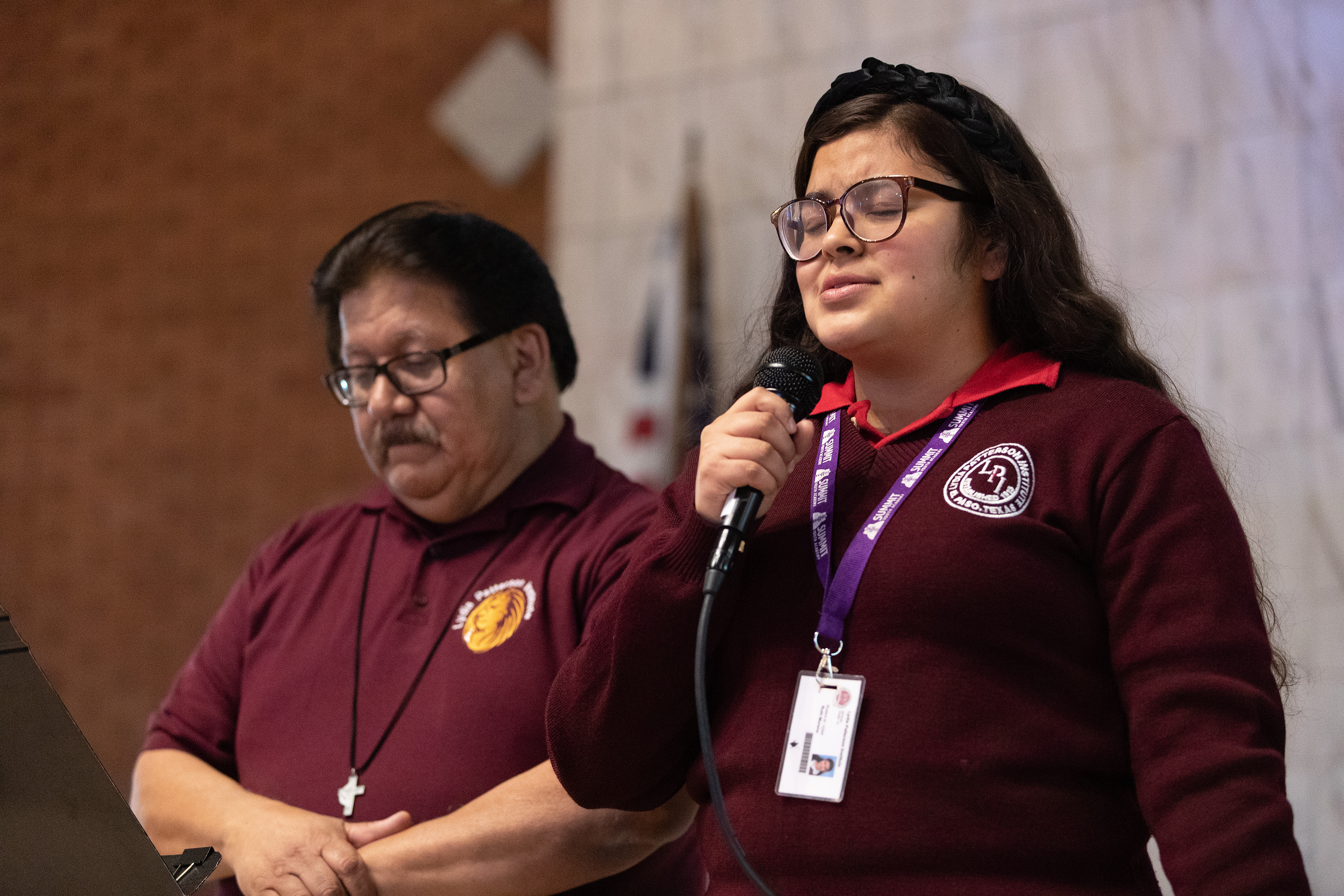 Ruth Moreno orando en el devociones de apertura en un día de clases regular. Ella es una de las estudiantes que cruza diariamente la frontera para asistir a sus clases en el Instituto Lydia Patterson de la iglesia metodista. Como como Ruth, cientos de estudiantes hispanos/as ven peligrar su futuro académico, ante los desafíos que vive la institución. A la izquierda está el capellán de la escuela, Rev. Santiago Heredia. Foto Mike DuBose, Noticias MU.
