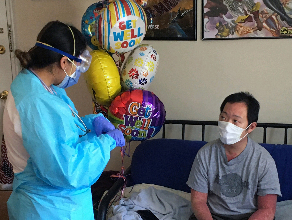 Chris Yuen (right) gets a bouquet of balloons during his hospital stay for the coronavirus. Yuen, a 32-year-old member of Midland Park United Methodist Church in New Jersey, spent about 20 days on a ventilator. Doctors and nurses lined the hall to cheer when he went home on April 22, after nearly a month’s hospitalization. Photo courtesy of Chris Yuen.