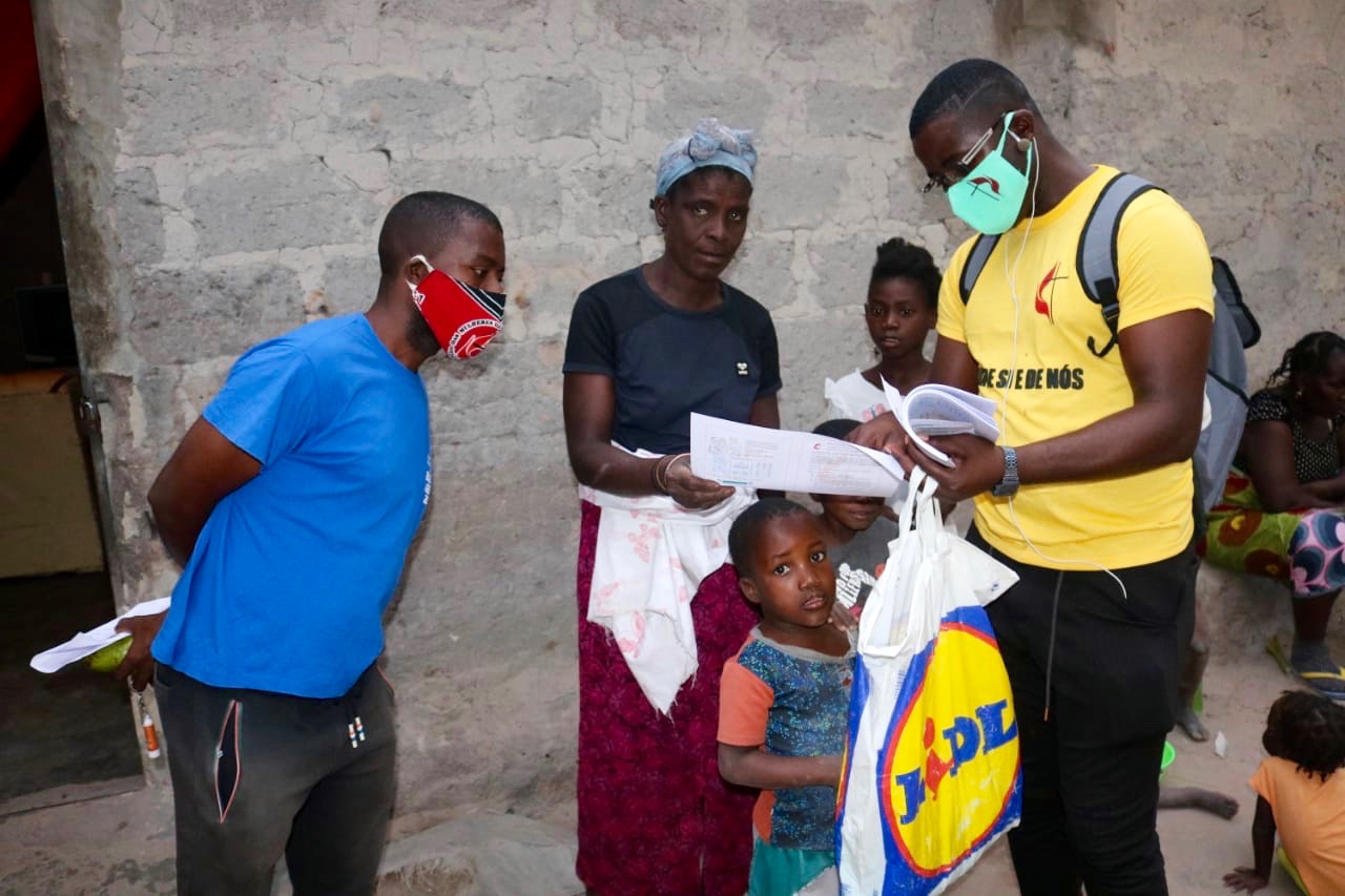 Beneficiários escutam atentamente a explicação sobre o valor do uso da máscara, e sobre os métodos a tomar para a prevenção da doença. Malange, foto de Gelson Carlos.