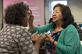 The Rev. Josephine Deere, right, blesses fellow Connectional Table member Benedita Penicela Nhambiu during a service of baptism remembrance on April 3, 2019 at the Connectional Table meeting in Nashville, Tenn. File photo by Kathleen Barry, UM News.