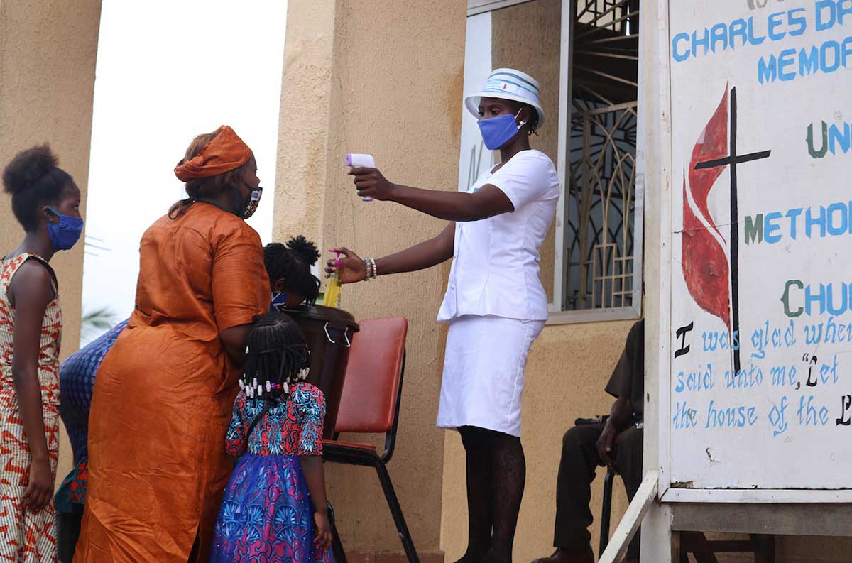 A churchgoer’s temperature is taken before she is allowed into the worship service at Charles Davies United Methodist Church in western Freetown, Sierra Leone, on July 19. Wearing masks and temperature checks are among the new guidelines for churches as the government lifted the ban on congregational worship. Photo by Phileas Jusu, UM News.