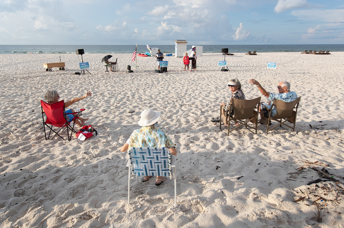 Worshippers greet one another from a distance at the Galilean Beach Service. Photo by Mike DuBose, UM News.