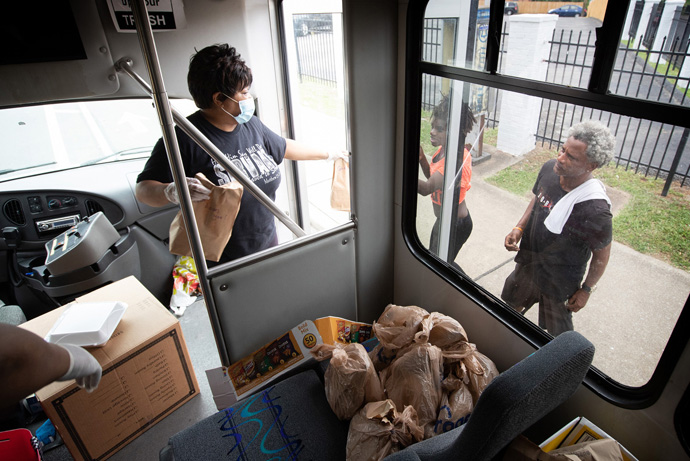 The Rev. Michelle Wilson offers sack lunches from the door of the church van as part of the Hands of Hope food security program at Gordon Memorial United Methodist Church in Nashville, Tenn. The church received a Sheltering in Love grant from the United Methodist Committee on Relief that has enabled it to expand existing food security ministries with seniors and persons experiencing homelessness during the COVID-19 pandemic. Photo by Mike DuBose, UM News.