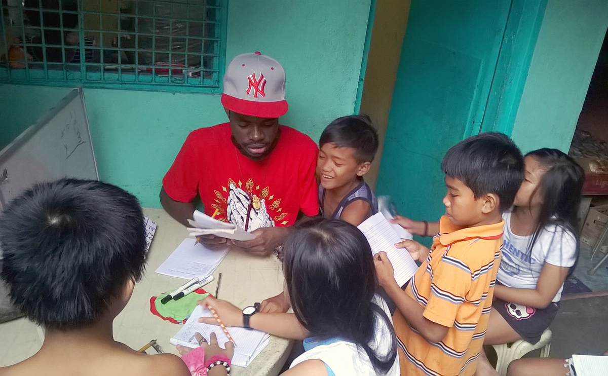 Global Mission Fellow Bellarmee Milosi gives a tutoring session for children in  Tramo, Philippines, as part of the Kapatiran-Kaunlaran Foundation Inc. With the current budget constraints, expansion of this successful young adult ministry is unlikely. 2018 file photo courtesy of Global Ministries.